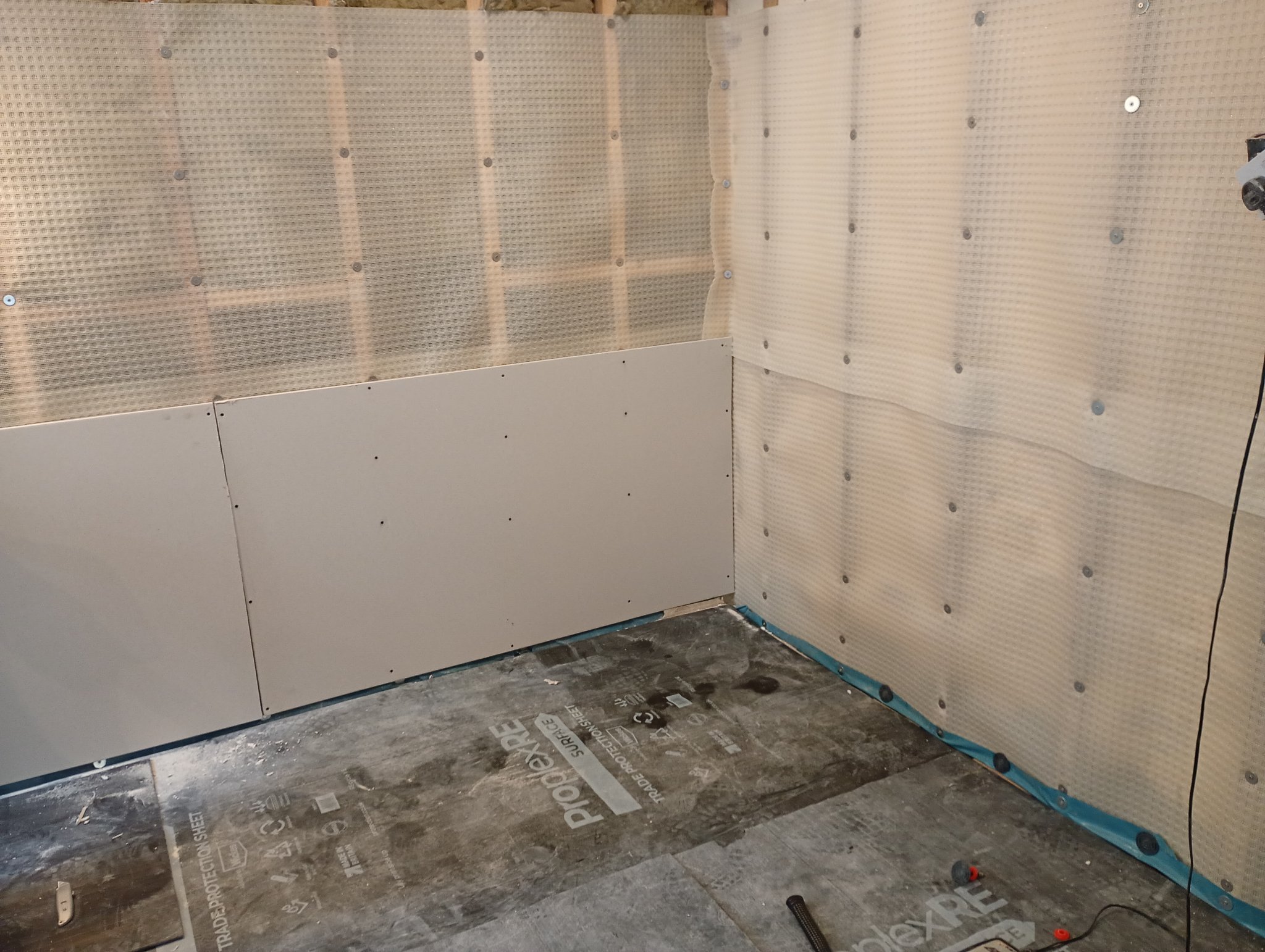 Damp proof membrane fixed to the basement walls with the first plasterboards going up